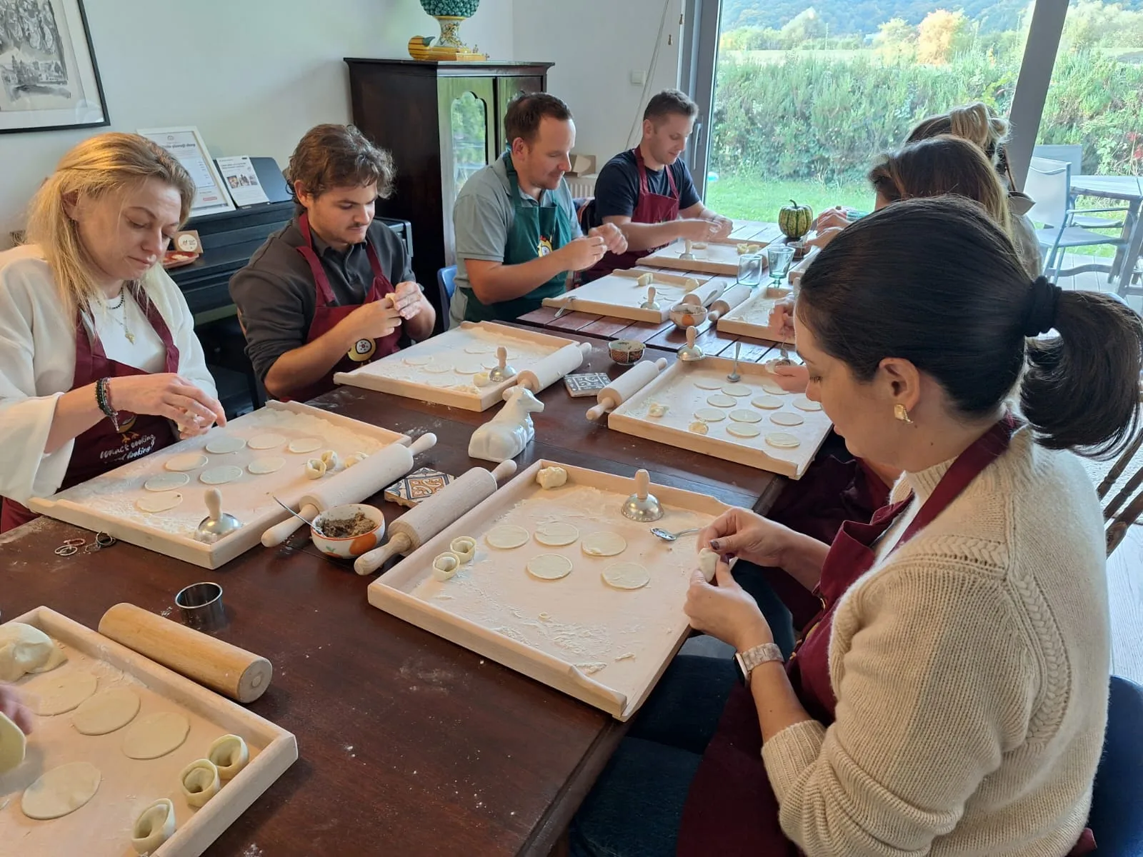 A group making pierogi together at a long table